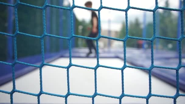 Red deportiva en el fondo en un campo de deportes donde los niños están saltando — Vídeos de Stock