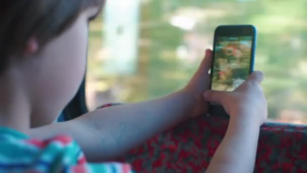 Un garçon monte dans un train et tourne une vidéo sur une caméra smartphone . — Video