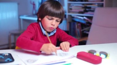 Çocuk çizimini bitirir ve ellerini kaldırarak sevinir.