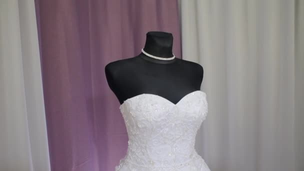 The wedding dress is dressed in a black mannequin — Stock Video