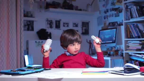 Home education process, a boy playing with light bulbs — Stock Video