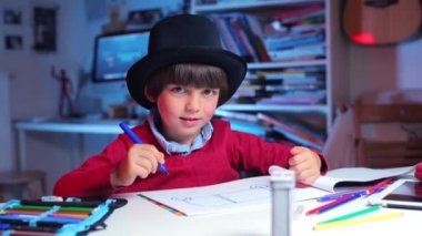 Okul masasındaki çocuk neticeye sevinir ve bir resim çizer.