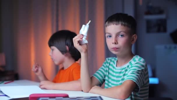 Portrait of two cheerful boys sitting at a table eating ice cream — Stock Video