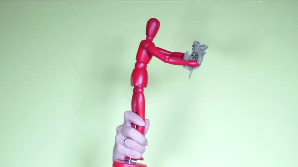 Handen håller figuren av en man med marijuana knopp — Stockvideo