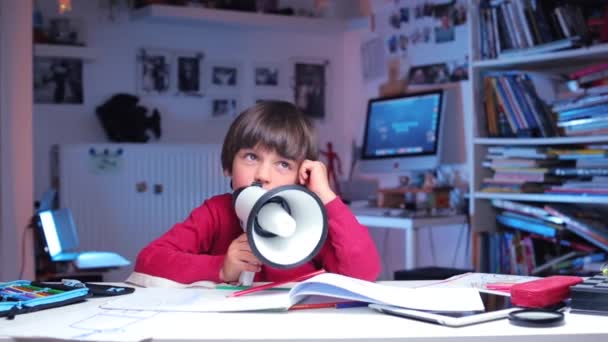 Băiat în haine roșii uitându-se la cameră și vorbind într-un megafon — Videoclip de stoc