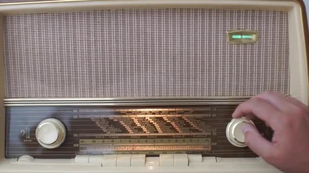 Collector demonstrates the performance of an old collectors radio — Stock Video