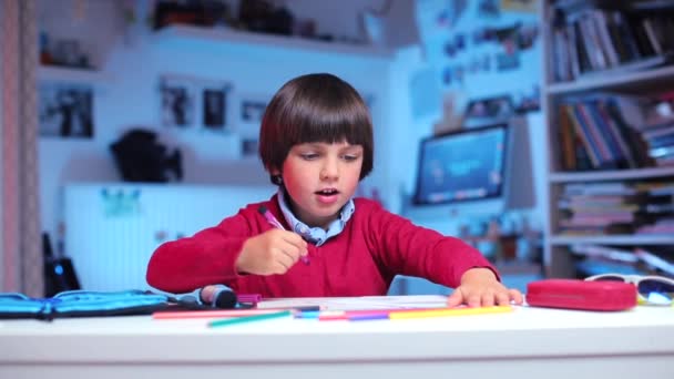 Хлопчик використовує маркери та олівці під час виконання домашнього завдання — стокове відео
