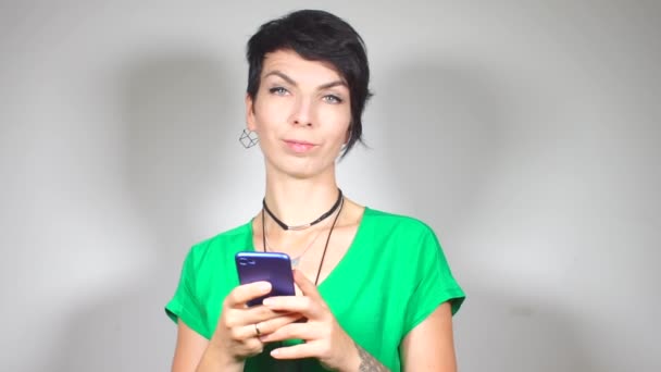 Ragazza guarda, utilizza uno smartphone, si aspetta — Video Stock