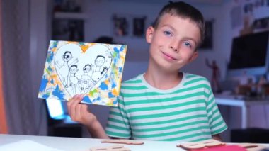 Çocuk ona bir aile fotoğrafı gösteriyor.