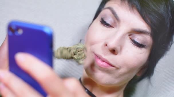 Meisje ruikt een nieuwe variëteit van cannabis, kijkt naar het telefoonscherm, — Stockvideo