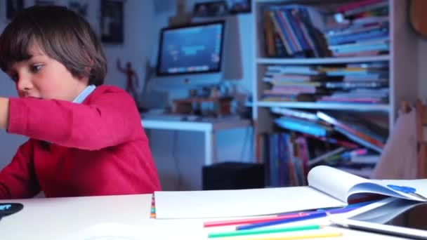 Um menino na mesa da escola brinca com luzes fluorescentes — Vídeo de Stock