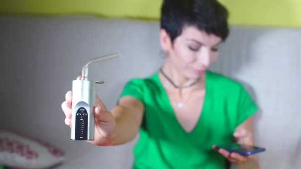 Flicka använder vaporizer när hon röker cannabis — Stockvideo