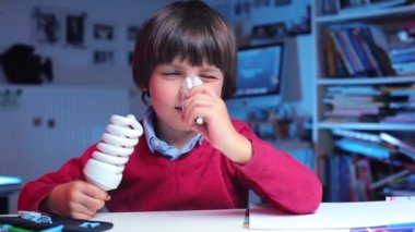 Çocuk iki enerji tasarruflu ampulle oynuyor.