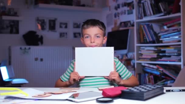 Schoolboy shows a white rectangle in his hands — Stock Video