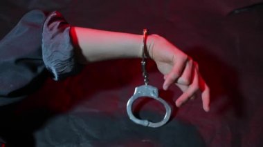 Elleri kelepçeli, hareket eden bir elin yakın çekimi..