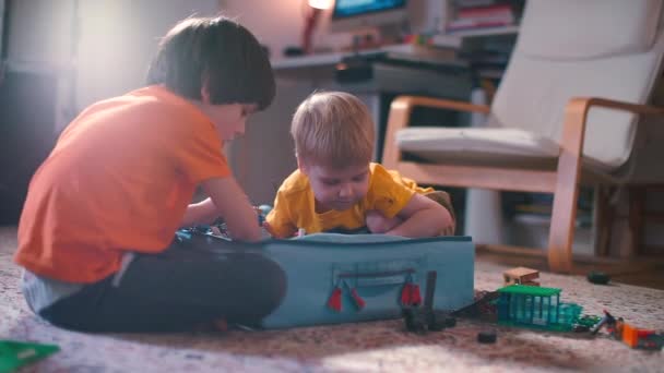 Dois meninos estão brincando com uma caixa de construtor . — Vídeo de Stock