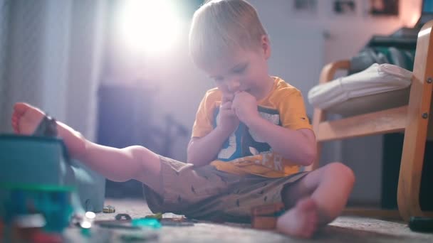 Ein Junge spielt mit einem Designer, der im Kindergarten auf dem Fußboden sitzt. — Stockvideo