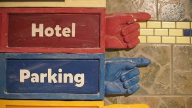 Şehir duvarında otel tabelaları ve park levhaları.