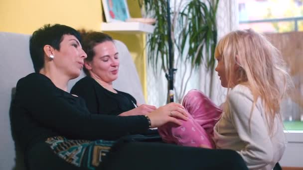 Lesbisk familj hemma på soffan med dotter. — Stockvideo