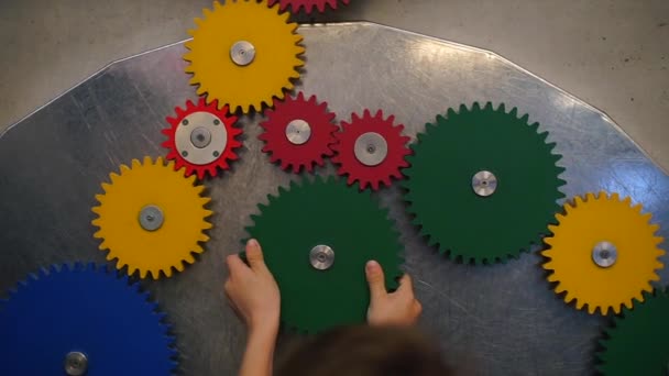 Close-up of hands spinning multi-colored gears — ストック動画