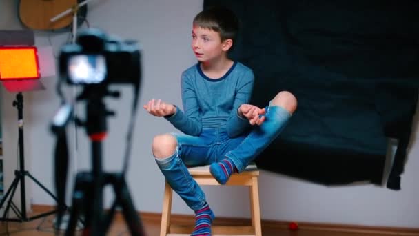 Chłopiec bloger mówi o temacie na kamerze skierowanym do niego. — Wideo stockowe