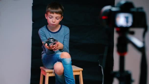 Un videobloguero infantil está haciendo una entrada de blog con cámara . — Vídeos de Stock