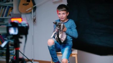 Çocuk bir kedi hakkında bir video bloğu hazırlıyor..