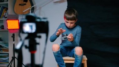 Okullu bir çocuk eski bir film kamerasıyla ilgili bir video blogu hazırlıyor..