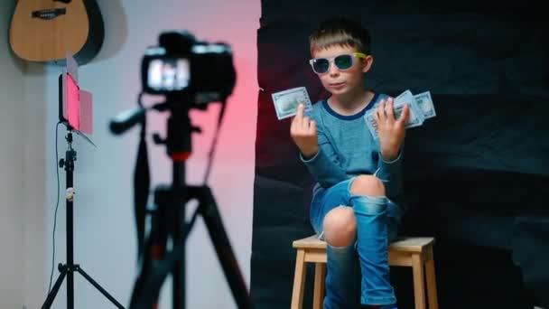 Un chico con gafas tiene billetes de dólares en sus manos. . — Vídeo de stock