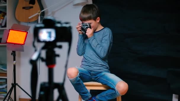 A teenager looks through the peephole of a camera while recording a video blog. — ストック動画