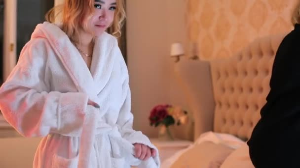 Bride of Asian appearance in a white bathrobe. — Stock Video