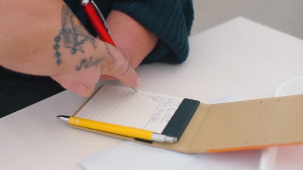 Disabled man shows a sample of his signature on paper — Stock Video