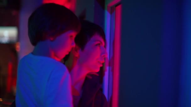 Mama i syn patrzą przez okno laboratorium kosmicznego.. — Wideo stockowe