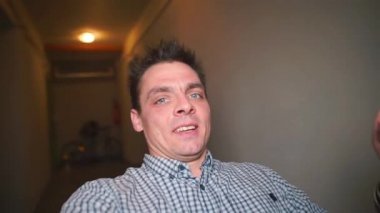 A man is filming himself on a video camera. Spins in place.