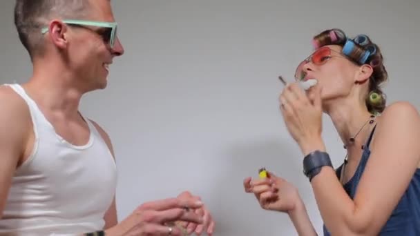 Kaveri ja tyttö polttavat kannabista ennen juhlia, kaveri pitää marihuanaa kädessään — kuvapankkivideo