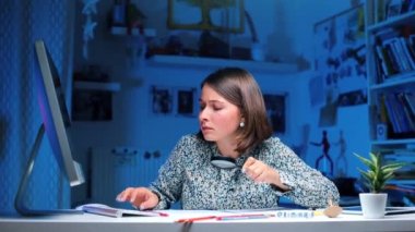 Öğrenci bilgisayarda oturup yeni materyaller üzerinde çalışıyor.