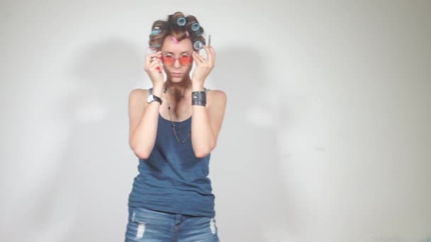 Девушка надевает очки, готовится курить косяк с коноплей — стоковое видео
