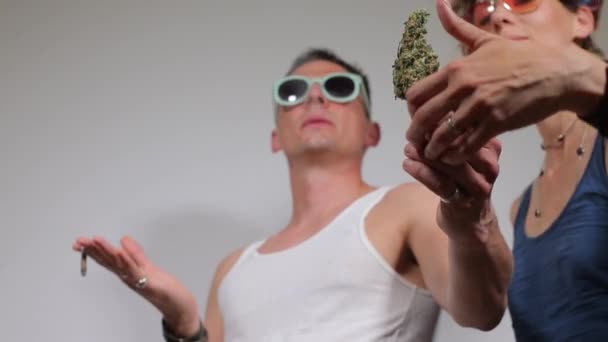 Marihuana w rękach faceta, para pali papierosa z marihuaną — Wideo stockowe