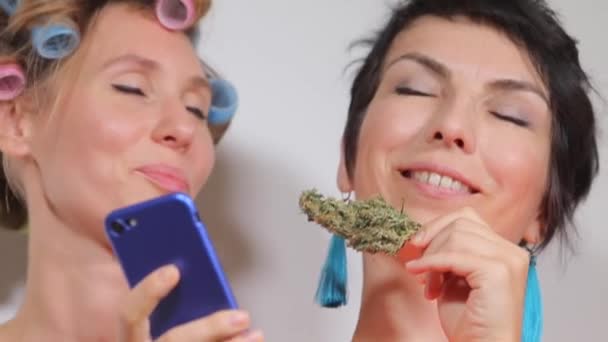 Deux filles examinent et reniflent le cannabis avant usage — Video