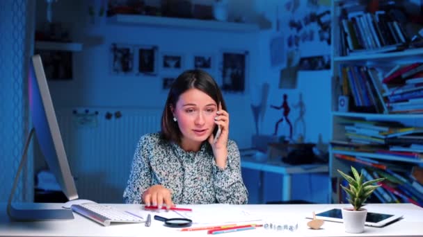 Emotional office worker talking on the phone at the table — Stock Video