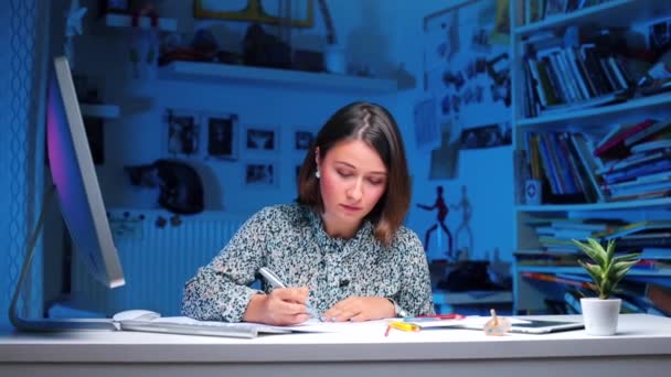 Meisje zit aan tafel schrijft tekst, shows als. — Stockvideo