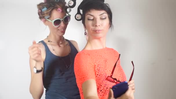 Две девушки готовятся к вечеринке в клубе, заканчивая свой стиль одежды — стоковое видео