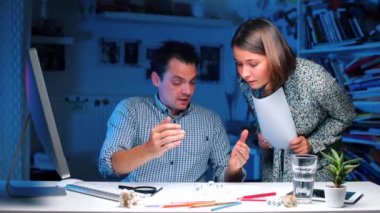 Ofiste masada oturan, zar atan, asistanıyla konuşan bir adam..