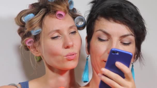 Две девушки смотрят на смартфон — стоковое видео