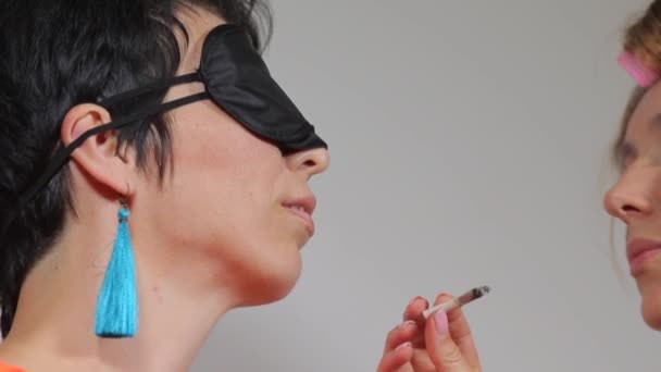 Dos niñas fuman cannabis de boca a boca — Vídeo de stock