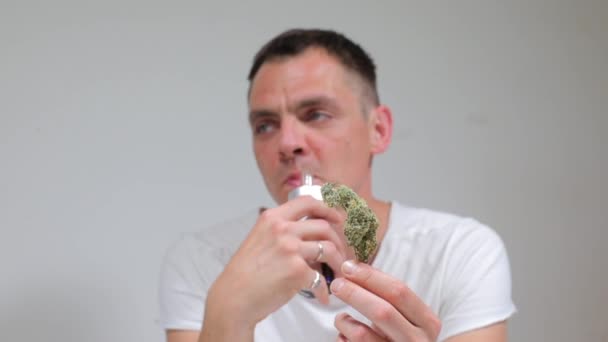 Paciente com câncer alegre usando cannabis através de um inalador, segurando uma planta em suas mãos — Vídeo de Stock