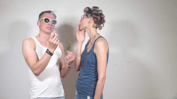 Mann und Frau rauchen Joint mit Cannabis, untersuchen eine Knospe Marihuana — Stockvideo