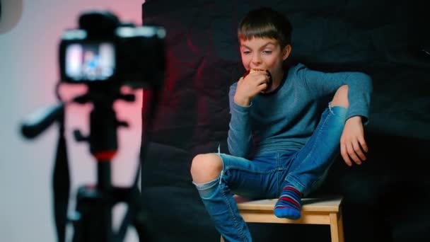 Arogantní teenager jí červené jablko a dělá video blog. — Stock video