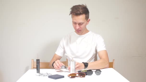 Vaporizer seller demonstrates how to charge cannabis into a tube — Stock Video