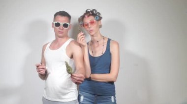 Bir erkek ve bir kız esrar içiyor, esrar tomurcuğunu inceliyor.